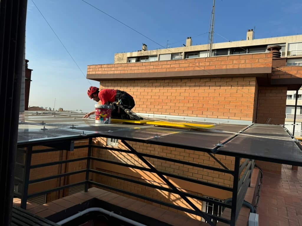 Operario de Verticals Barcelona trabajando sobre una cubierta acristalada