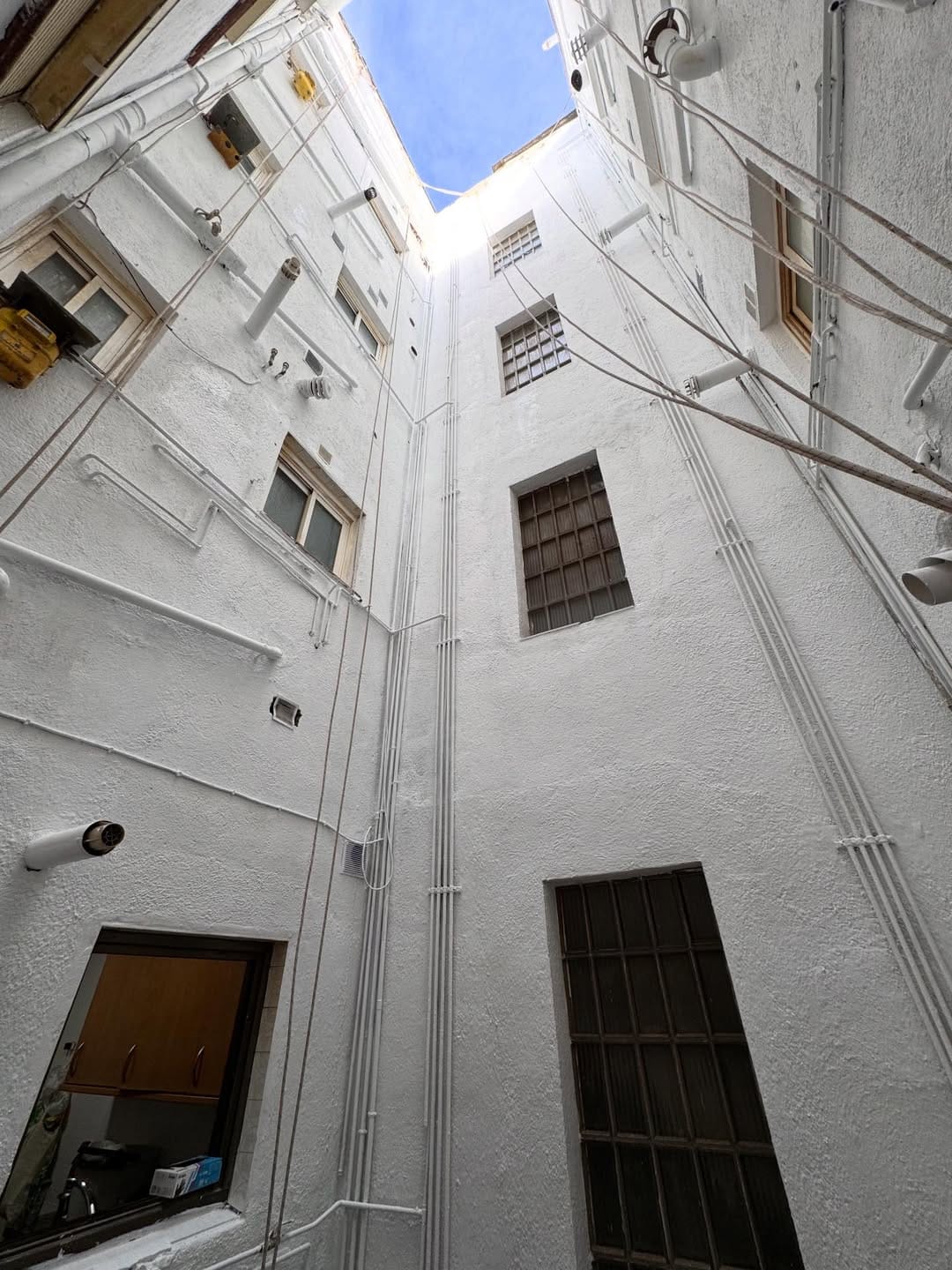 Ventanas y conducciones en una fachada de patio interior
