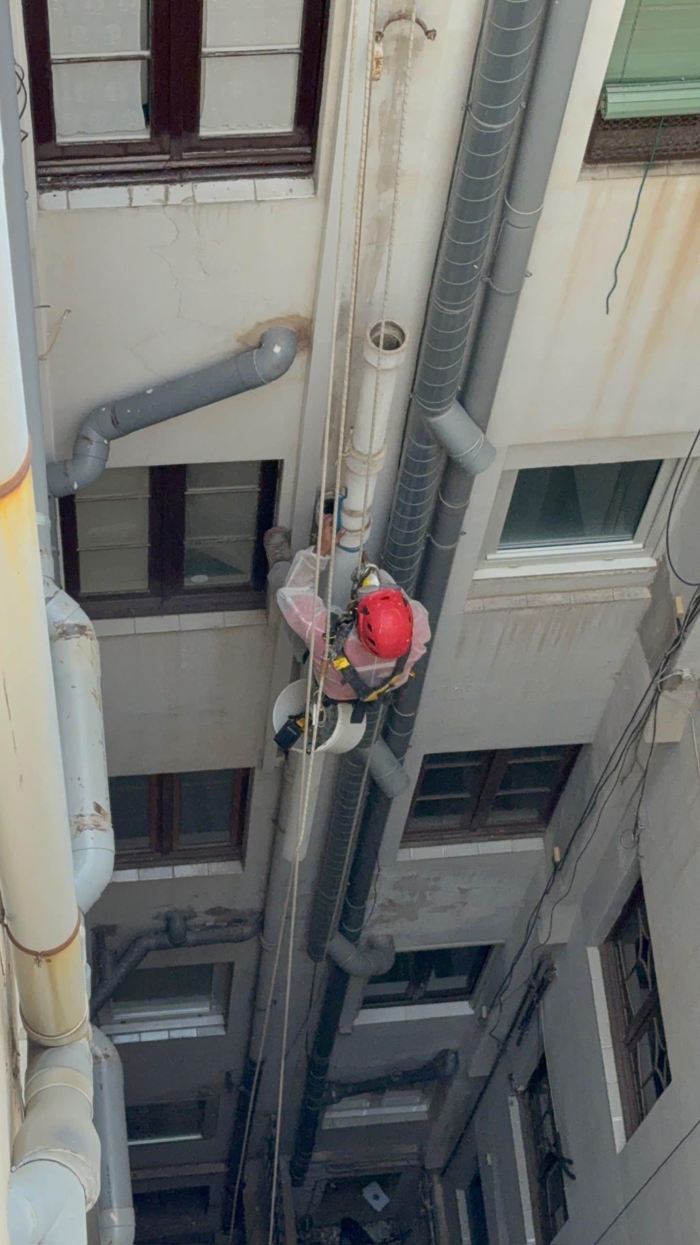 Técnico de Verticals Barcelona trabajando con cuerdas en un patio de luces