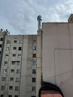 Instalador de salida de humos Barcelona trabajando en fachada con acceso vertical