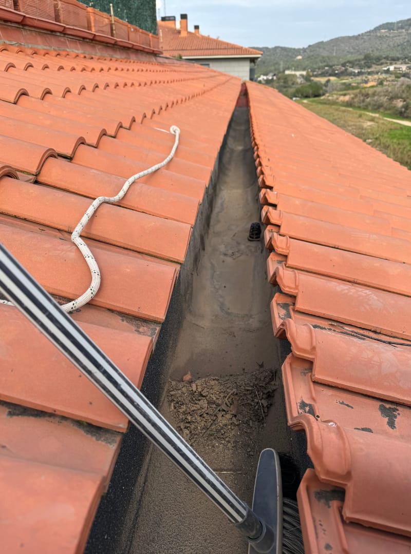 Clogged gutters in Barcelona during a manual cleaning