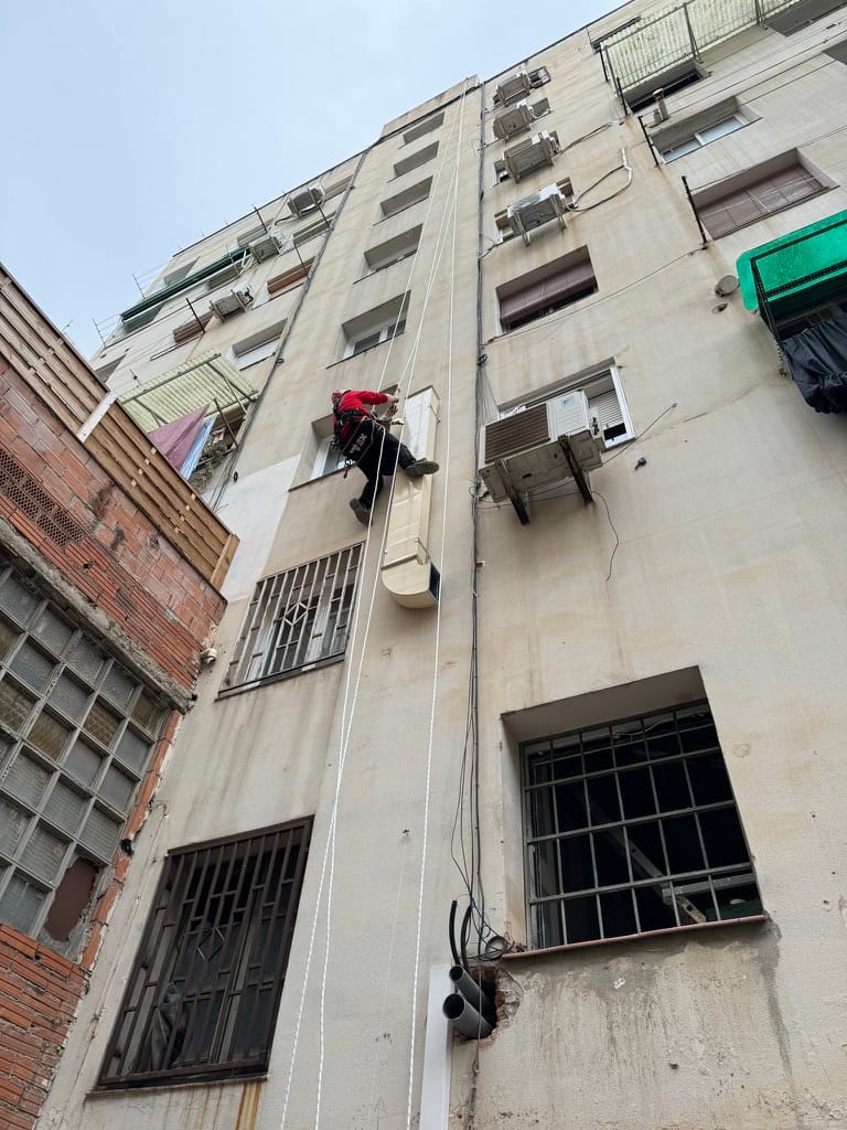 Conducte de sortida de fums instal·lat a façana d'edifici a Barcelona