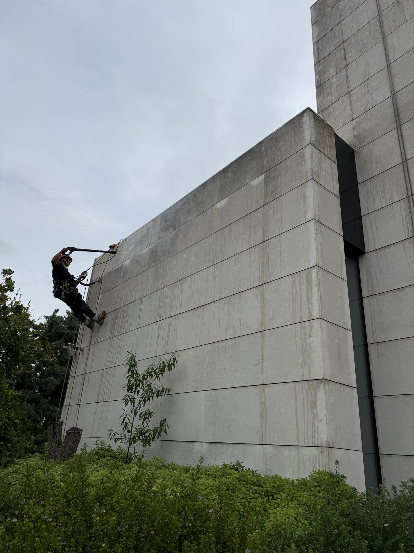 Operari de treballs verticals netejant façana de xalet a Vallvidrera