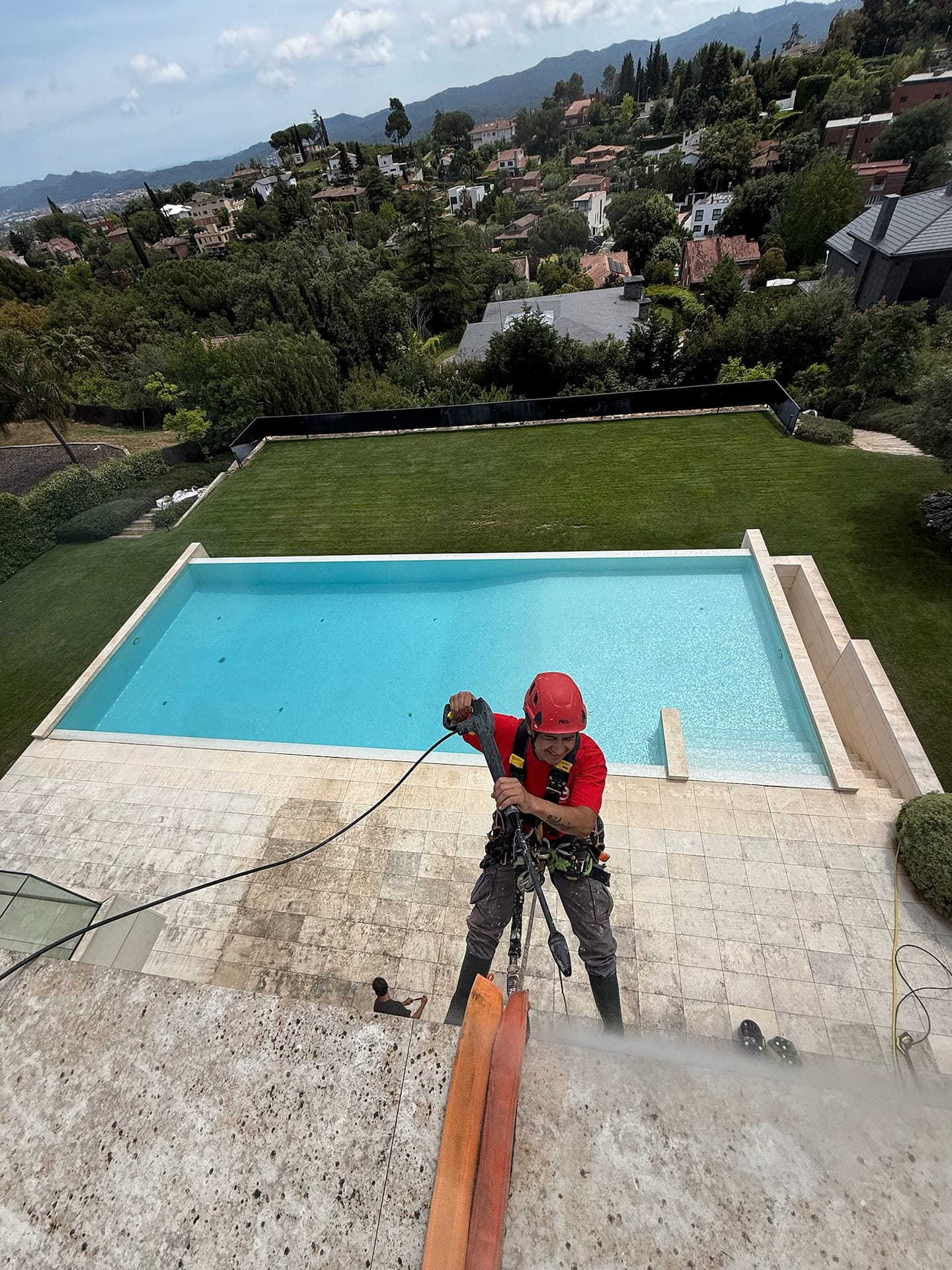 Tècnic en corda treballant amb xalet amb piscina a Vallvidrera Barcelona
